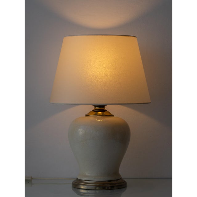 Elegant pair of French classic urn or ginger jar shaped table lamps in a warm cream craquelure glaze with subtle gold...