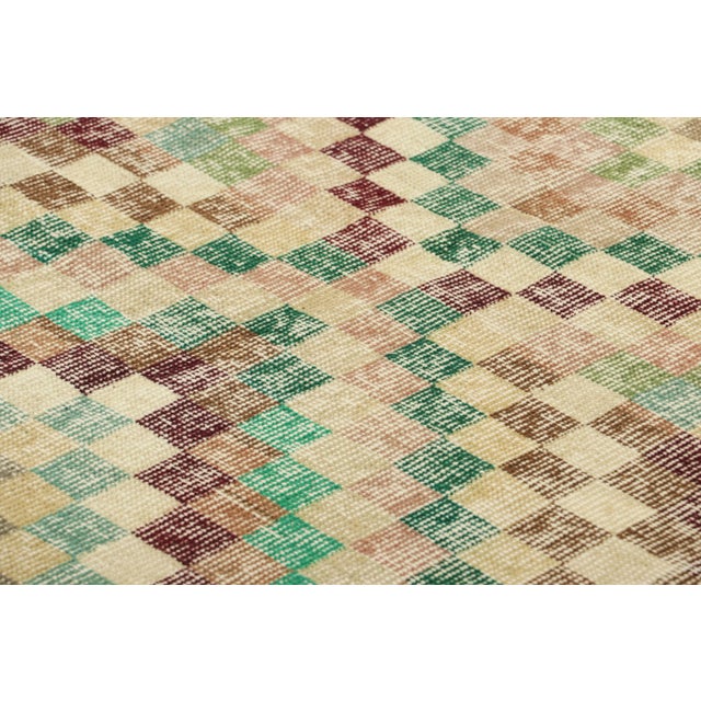 Hand-knotted in wool and originating in Turkey circa 1950-60, this 3x6 vintage Zeki Müren runner rug is a unique addition...
