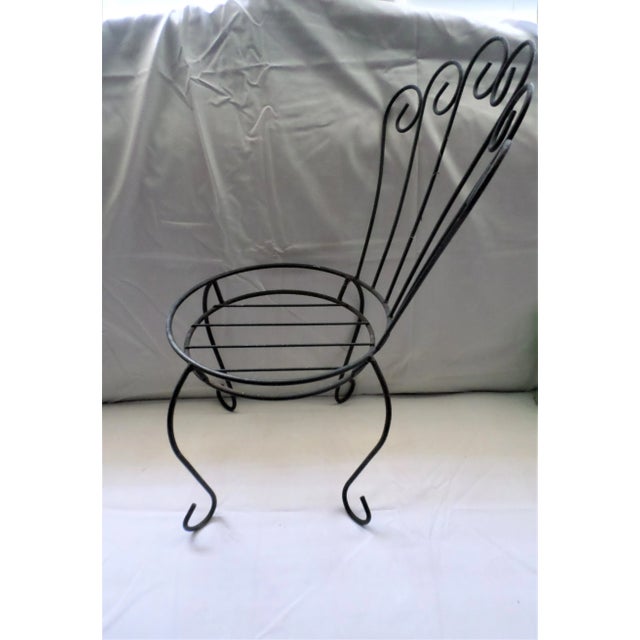 This is a Sweet Vintage Black Metal Plant Stand / Flower Holder in the Shape of a Chair that stand 20" tall and 14" wide...