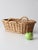 This vintage wicker basket features an elongated oval form with twisted side handles and a warm natural tone throughout....