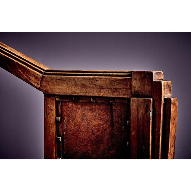 A striking early Art Deco armchair distinguished by its sharply faceted geometry and stepped side profiles. Constructed in...