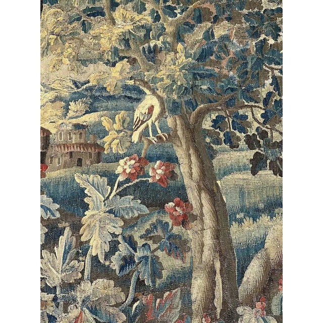 A finely woven 18th century Franco-Flemish verdure tapestry, featuring a bird perched within a lush flowering Baroque...