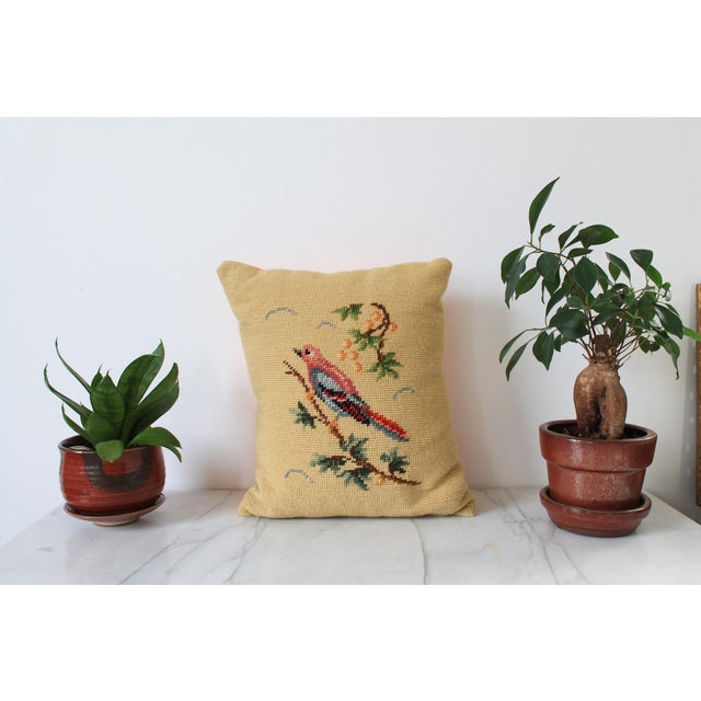 Vintage needlepoint accent pillow with bird motif. No makers mark. Sewn a little uneven. Orange backing. Minor age wear.