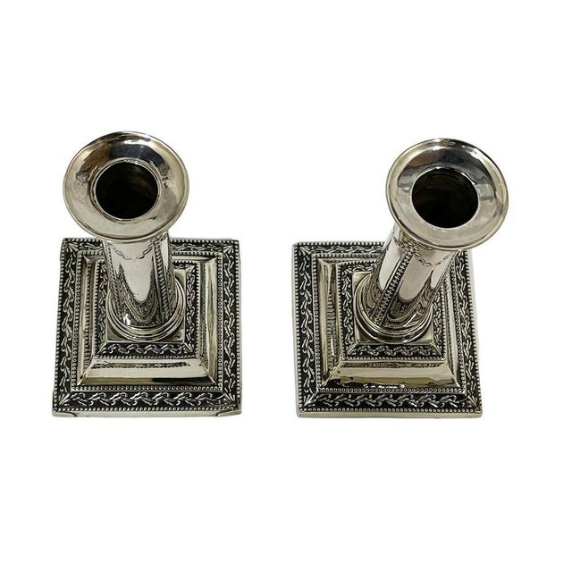 A pair of column candlesticks made of silver by Thomas Bradbury in 1904, Sheffield. The candlesticks are hallmarked...