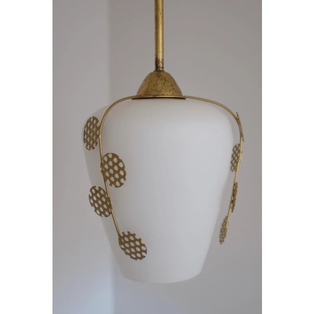 Swedish Modern light pendant with beautiful leaf ornament in brass and white frosted glass. Three decorative leaf...