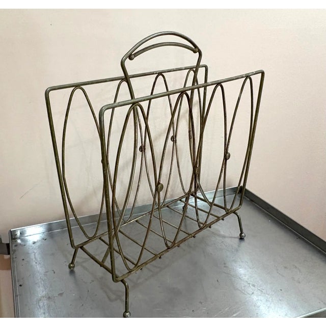 1950s-60s midcentury brass atomic-style magazine rack. Some patina to metal throughout as shown.
