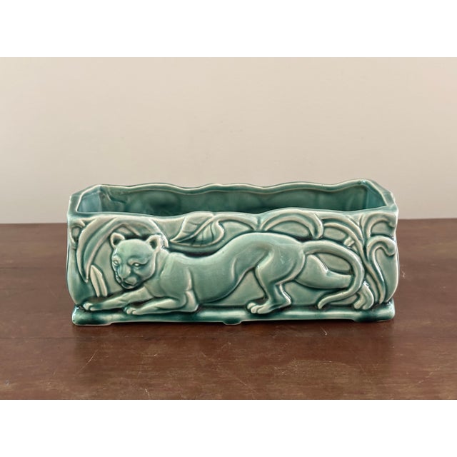 A stunning mid-century modern rectangular ceramic console planter featuring a highly stylized, embossed relief of a...