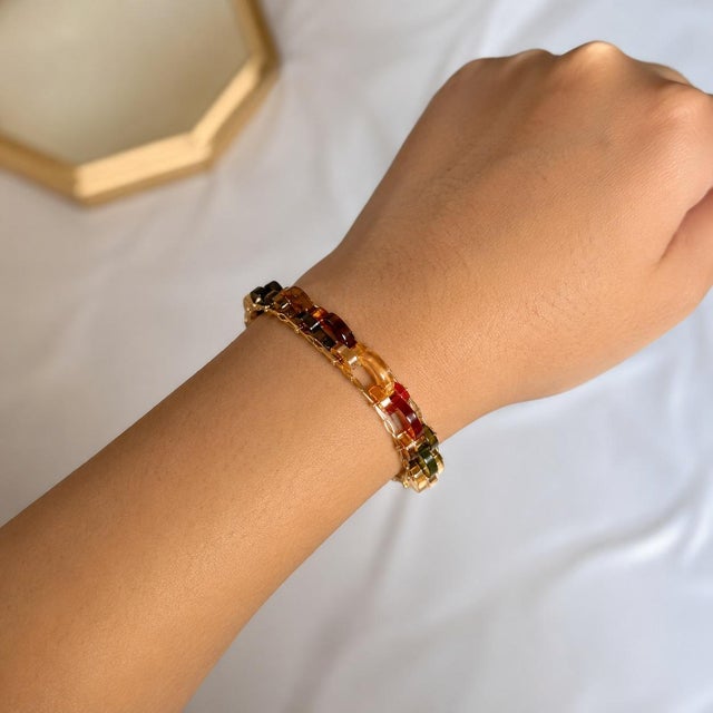 Bold 18K yellow gold designer link bracelet featuring 13 hand-carved multi-colored agate segments. Each agate showcases...