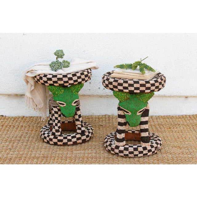 Look past the beadwork for a second and you'll see what's actually holding these stools up: a carved leopard figure on...