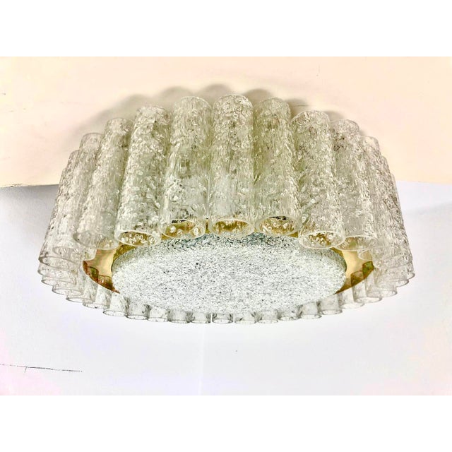 6 flames, the light is softly diffused by a dome and 32 glass cylinders hanging on the sides. This piece is attributed to...