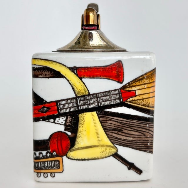 An elegant and highly collectible vintage ceramic table lighter by Piero Fornasetti, from the celebrated “Strumenti...