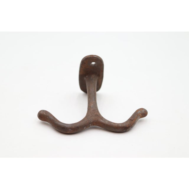 Vintage ceiling mount double arm hook made of cast iron with a black finish. The original mounting screws are not...
