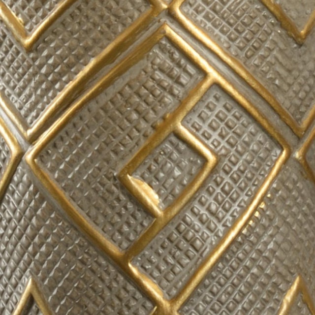 Interpreted from an african kuba cloth,this textural pattern translates modern in our kuba lamp in a gray and gold finish...