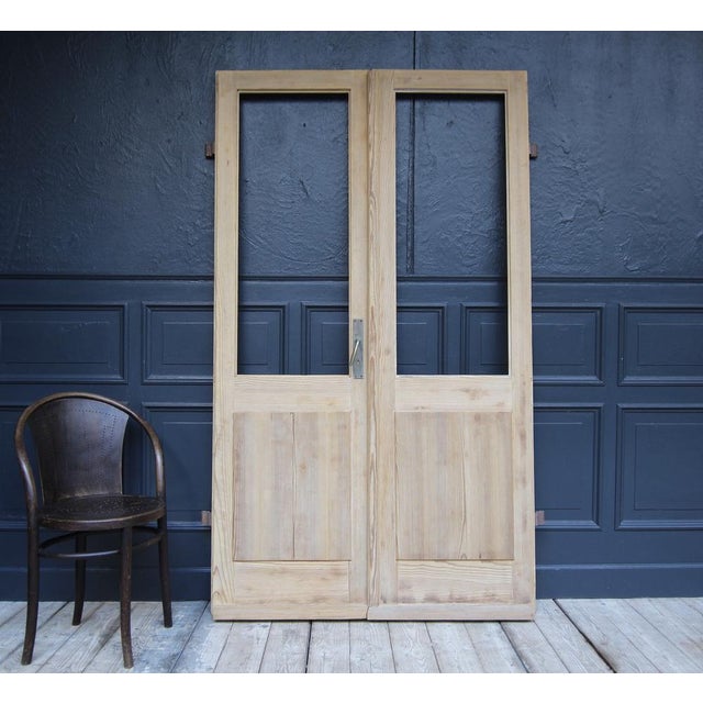 Pine wood double door from Switzerland. Early 20th century. Unrestored. Consisting of two originally half-glazed doors in...
