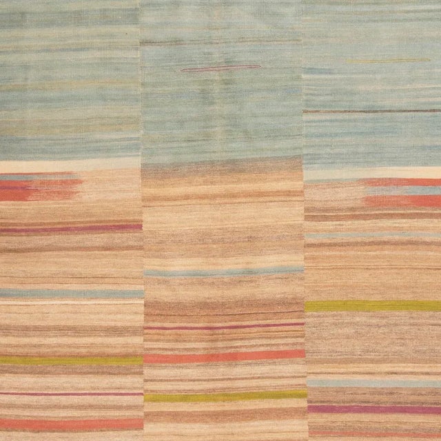 Originating from Pakistan, this modern transitional wool kilim is of a unique family woven in vertical panels, each of the...