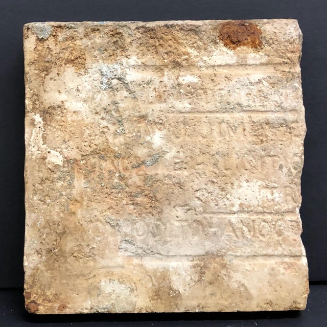 Antique Spanish tin-glazed tile features a stylized head of a satyr, widely identified as the Greek god Pan, the deity of...