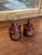 Pair of ceramic salt and pepper shakers shaped as miniature jugs, each with a side handle and hand-painted lettering that...