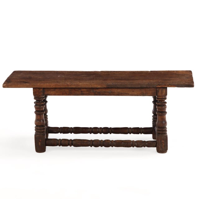 featuring a molded-edge rectangular top raised on substantial turned legs joined by a box stretcher. Originally of greater...