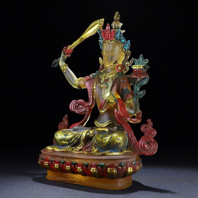 This is a striking and vibrant sculpture of the Manjushri Bodhisattva, crafted from translucent Liuli (pate de verre)...