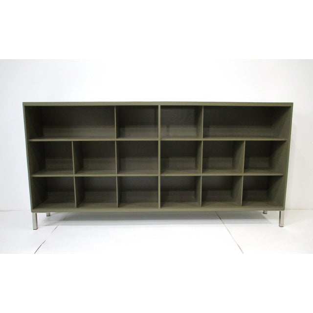 A well-crafted storage cabinet, credenza or bookcase with four tangerine perforated sliding Masonite doors having brass...