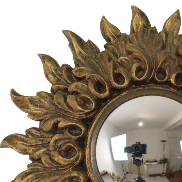 Small vintage sunburst mirror with convex glass, crafted from gold-colored resin and elegantly adorned with acanthus leaf...
