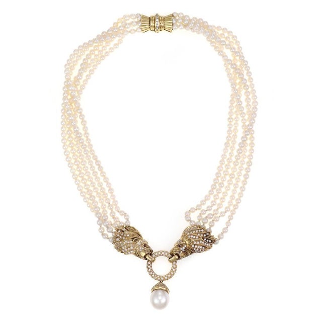 This is a gorgeous Estate necklace, it is crafted from 18k yellow gold featuring a double lion head with an open ring in...