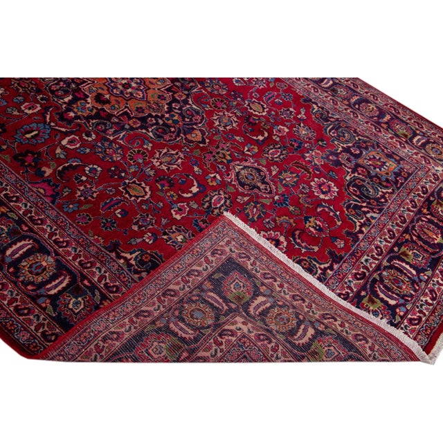 Beautiful vintage Persian Tabriz hand-knotted wool rug with a red color field. This piece has a blue frame and multicolor...