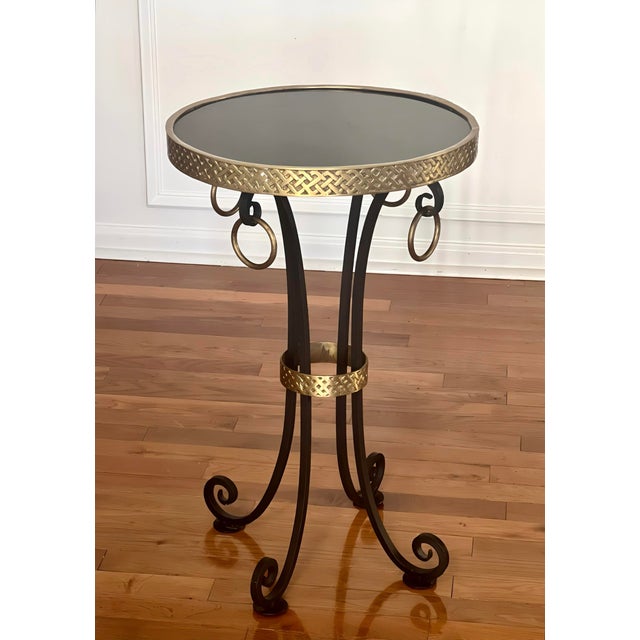 Iron and brass gueridon with polished black granite top crafted in the mid 20th century. Beautiful side table featuring a...