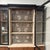 Beautiful vintage breakfront. Has black and wood tones with cool rope trim. Inside, there's decorative wallpaper lining...