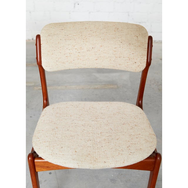 Frame made of solid teak. Upholstered in fabric. The seats of three of the chairs have been reupholstered. One chair has a...