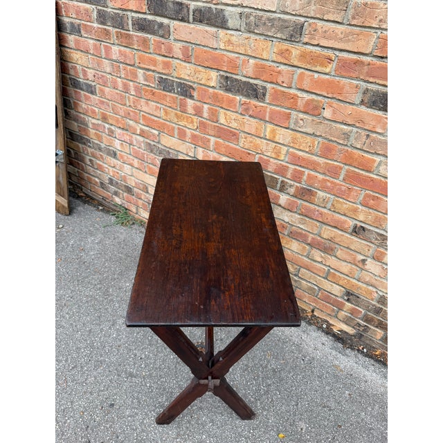This is a versatile English tavern side table with X frame base. It has a lovely wood top with patina and country...