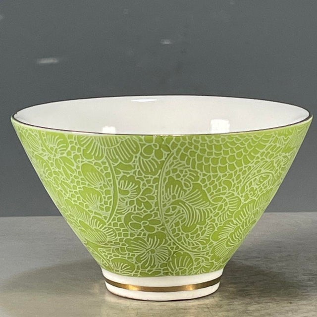 This is a striking vintage porcelain teacup, decorated in the famille rose palette with vibrant polychrome enamels. The...