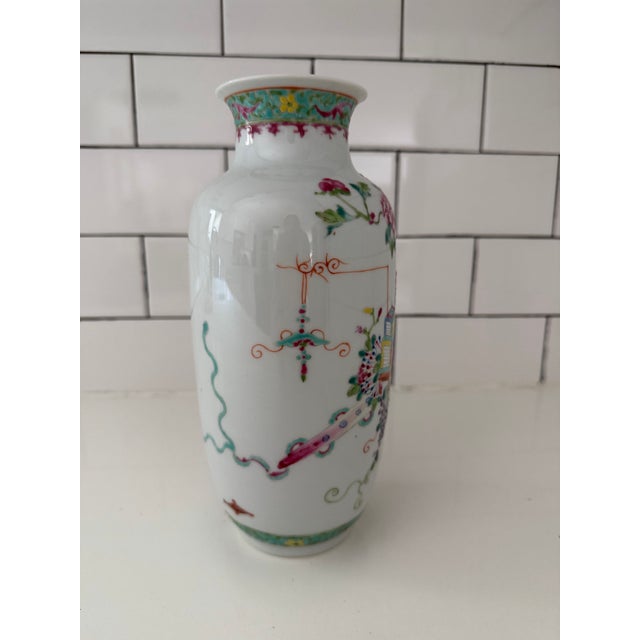 This Chinese Famille Rose porcelain vase features a colorful still life design. A porcelain vase designed with a...