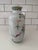 This Chinese Famille Rose porcelain vase features a colorful still life design. A porcelain vase designed with a...