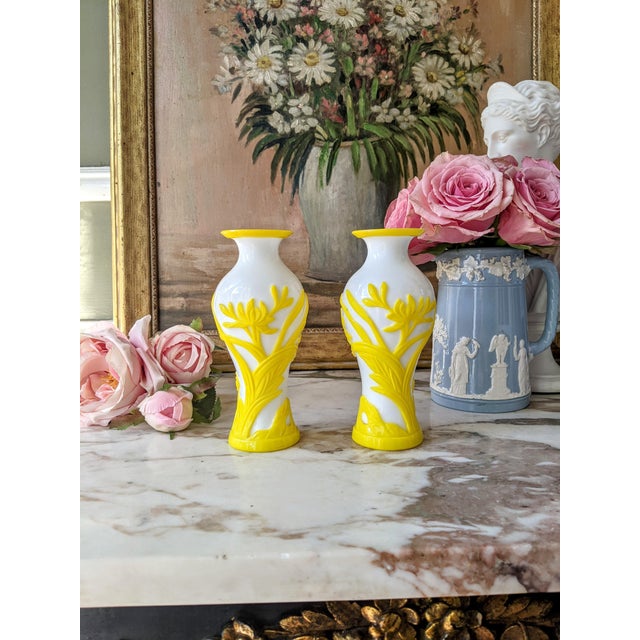 Striking pair of late 19th-century art glass vases featuring substantial opaque white glass bodies with vivid yellow glass...