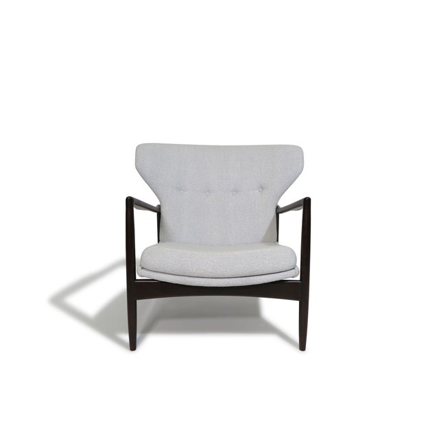 Danish Modern lounge chair and ottoman designed by Ib Kofod-Larsen, Denmark, circa 1956. Finely sculpted beech frame, in a...