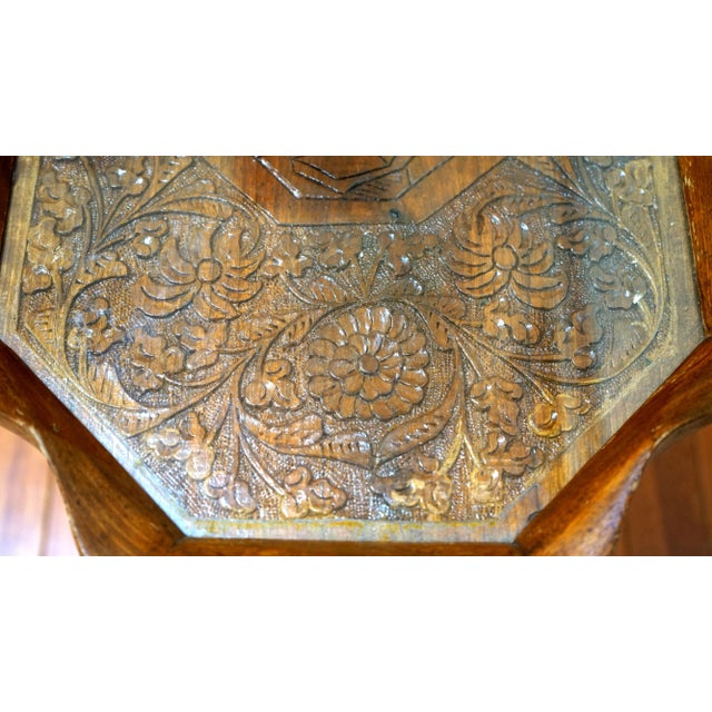 The absolute attraction of this table is the intricate carving on the top, which includes a centerpiece portrait of a...