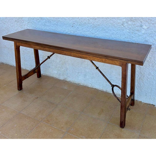 Bourgeois table, 18th Century Spanish. Made of walnut wood with Saint Anthony legs and iron stretcher.