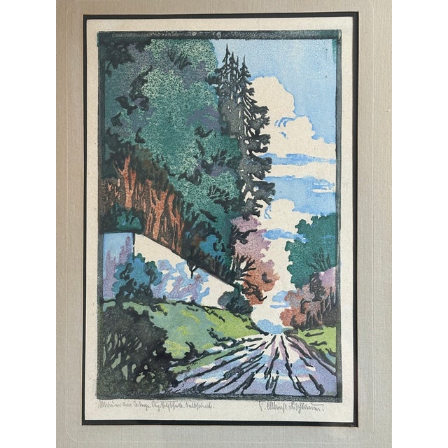 This framed artwork is a lovely example of Arts and Crafts Movement woodblock printing. The color wood block print shows a...