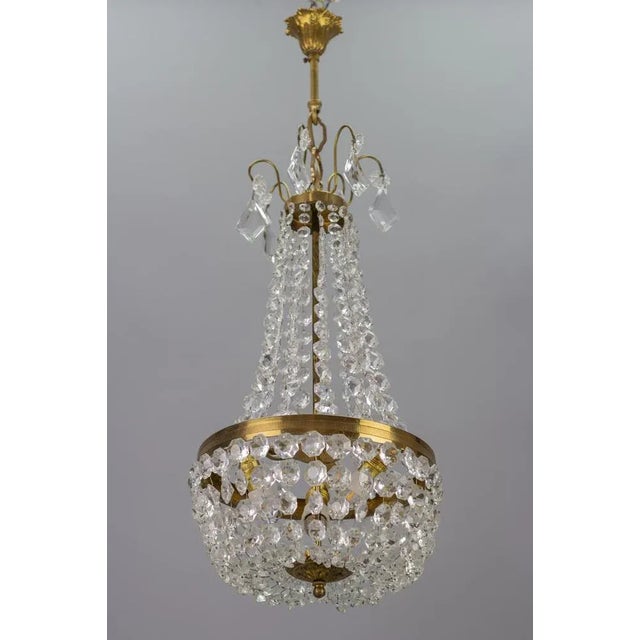 - Adorable French Empire-style crystal glass and brass chandelier from the 1950s. - This lovely piece has a brass and...