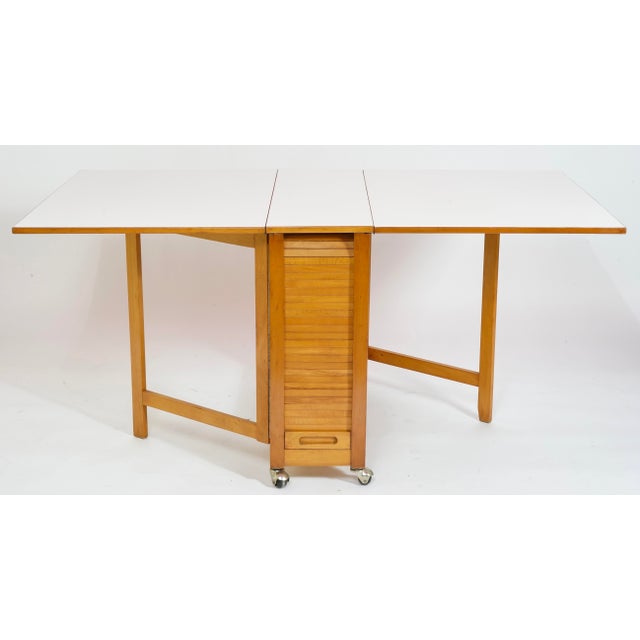Impressive vintage modern compact design features a drop-leaf table with a white laminate top and four fold up dining...