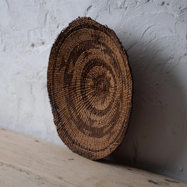 A Karuk winnowing tray basket, circa 1900. 11 ¼ by 11 inches; 2 inches deep