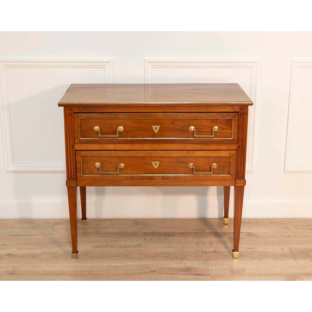A refined Louis XVI–style chest of drawers crafted in cherry wood and cherry veneer, distinguished by its architectural...