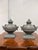 Design Plus Gallery presents a Pair of Neoclassical Style Decorative Faux Urns. Each urn has a silhouette with a pointed...
