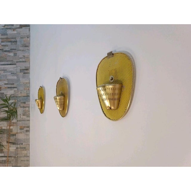 A very chic and iconic set of three wall sconces by Mathieu Matégot for Ateliers Matégot. France, 1950s. Very rare pieces...