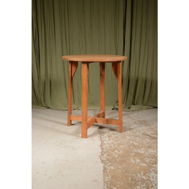 A craftsman made Cotswold School circular table, with a veneered pale oak top on four stop chamfered legs united by a...
