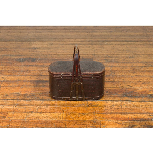 An antique Chinese rattan and bamboo lunch box from the early 20th century, with geometric motifs. Crafted in China, this...