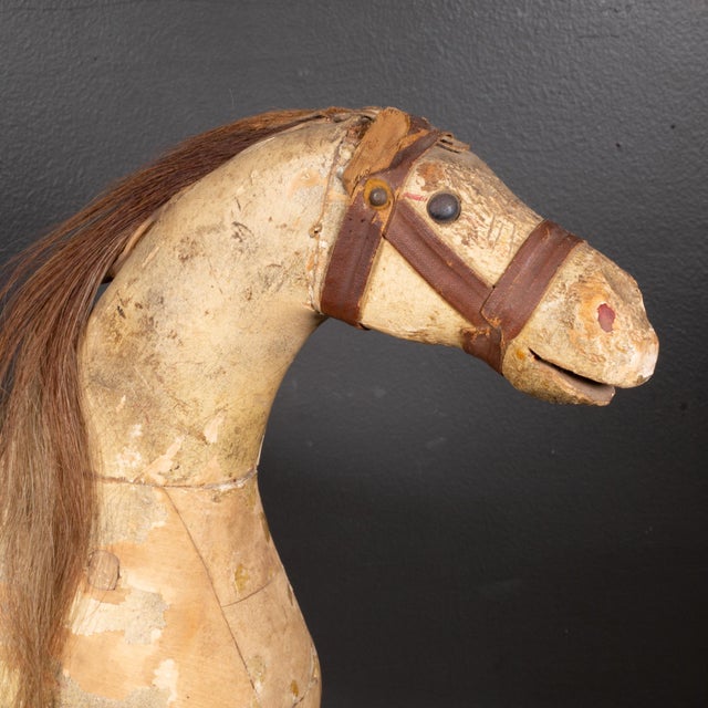 ABOUT A mid to late 19th century carved wooden horse with horsehair mane and tail, fabric ears, saddle, harness and nail-...