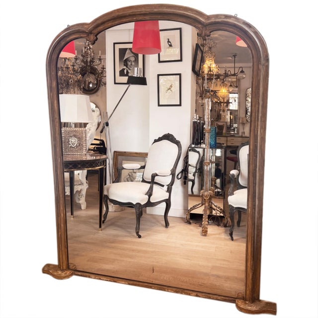 A very large late 19th century French mirror with a distinctive architectural shape. The moulded wood frame has a worn,...