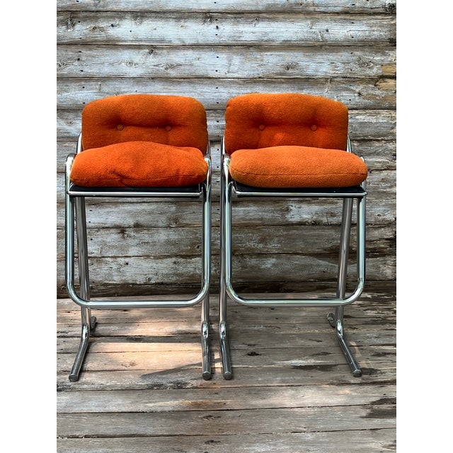 Pair of 1970’s ISO Jerry Johnson chrome barstools with original orange nubby upholstered seats. There are no markings to...